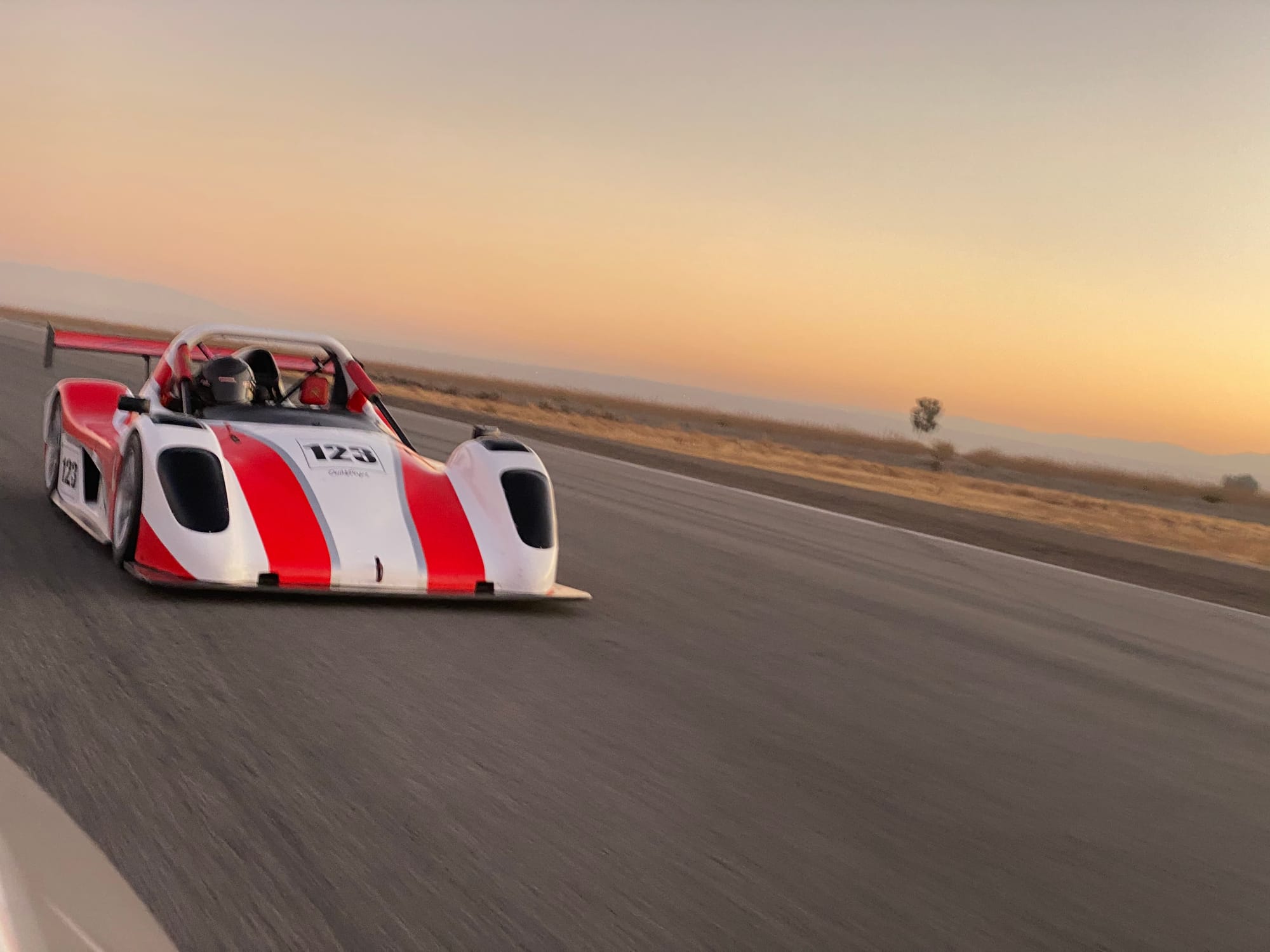 A race car at speed on track at Buttonwillow Raceway Park.